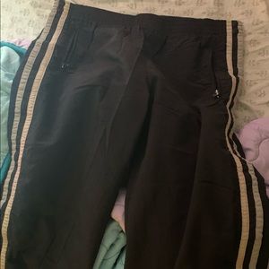 Black exercise/track pants with white stripes on the sides.